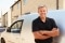 Portrait of middle aged tradesman standing by his van